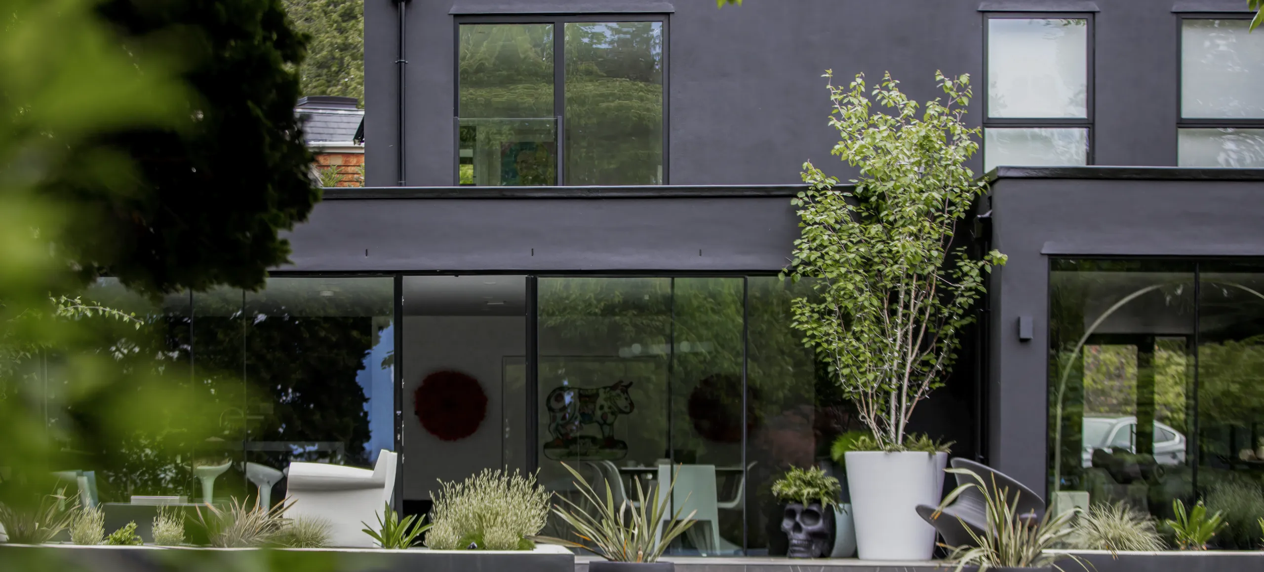 Charcoal House, Bromley: dark rendered rear elevation with full-width glazing