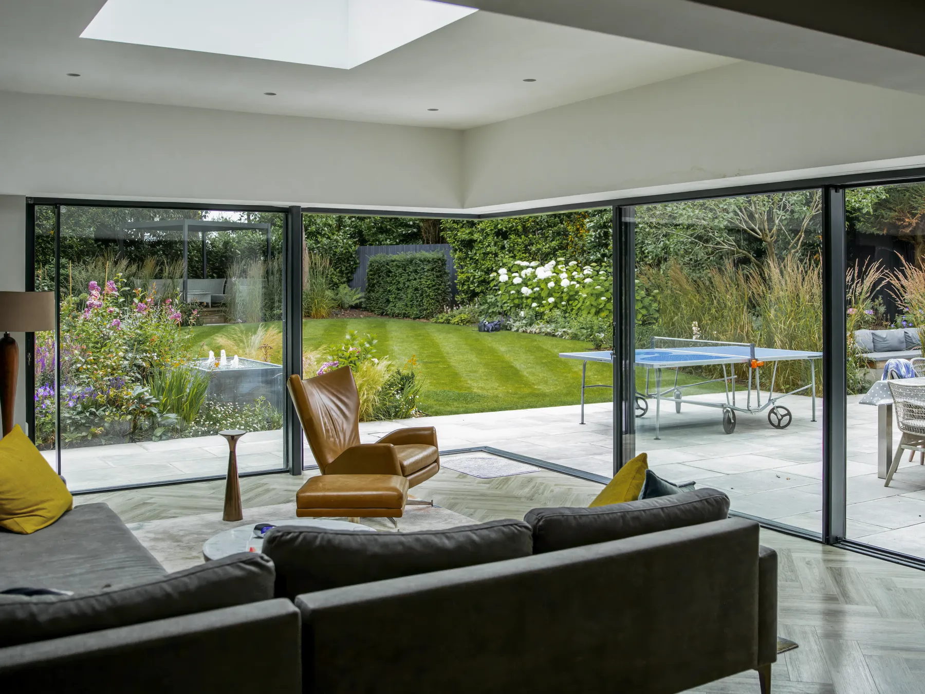 View from the living space through slim sliding glass to the garden