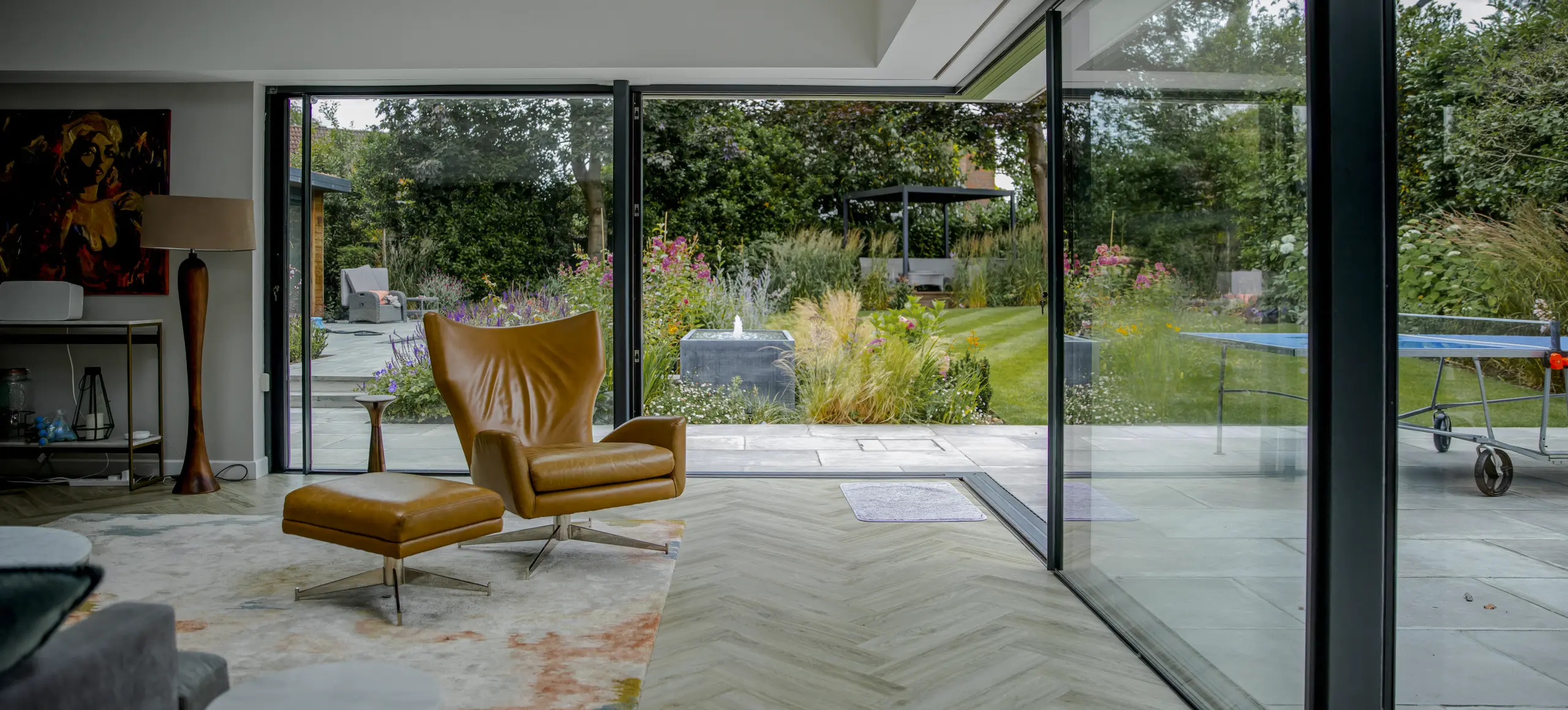 Panoramic House, Esher: slim sliding glazing opening a living room to the garden