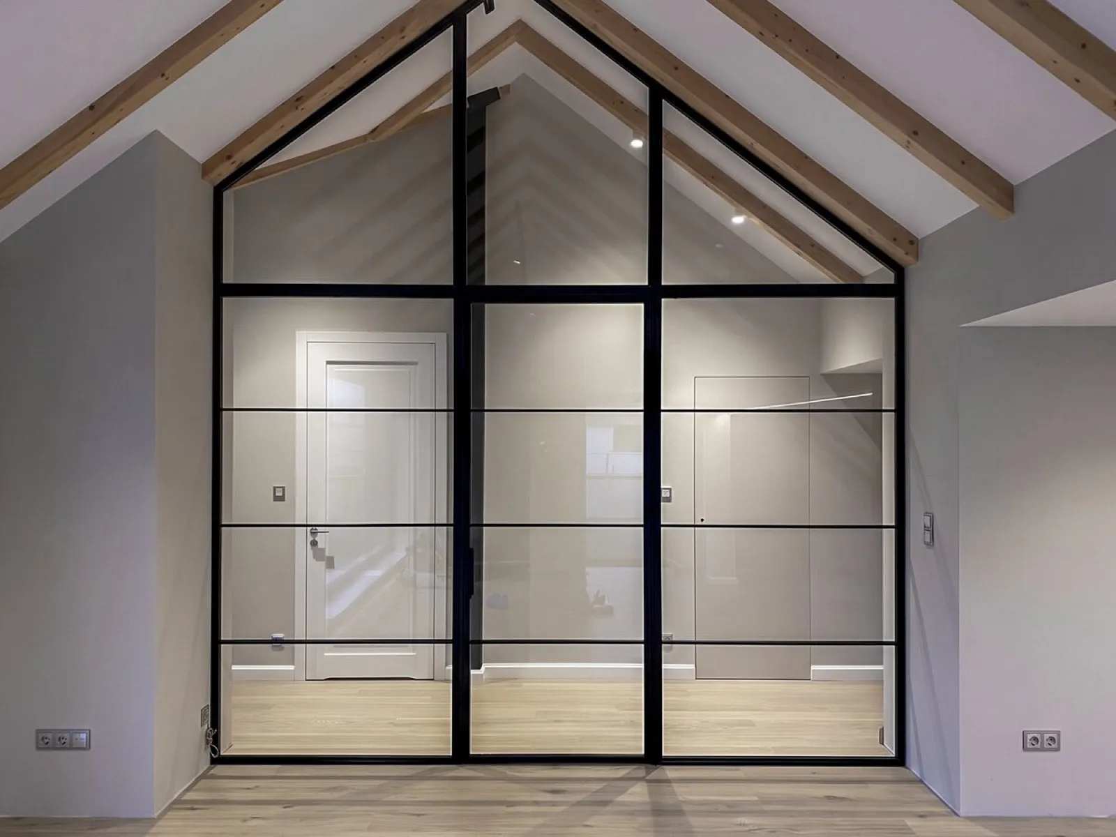 Hand-welded steel Crittall-style screen under a vaulted roof
